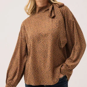 La blouse avec nœud au col à l'épaule